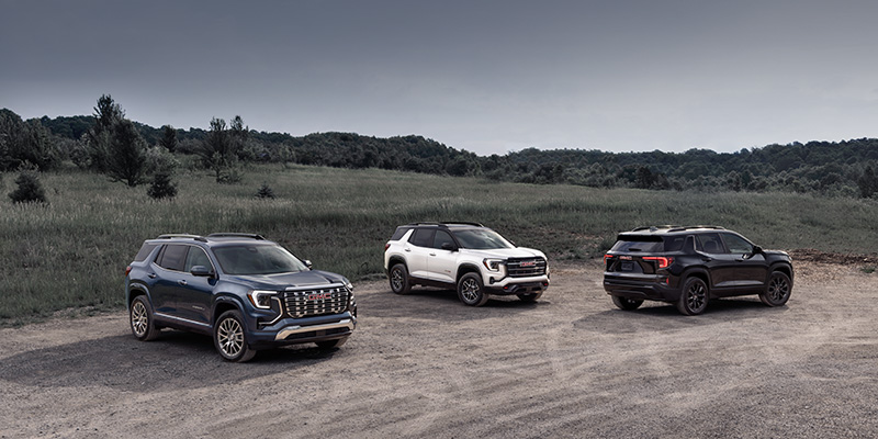 2026 GMC SUV lineup featuring multiple models parked in an outdoor landscape.