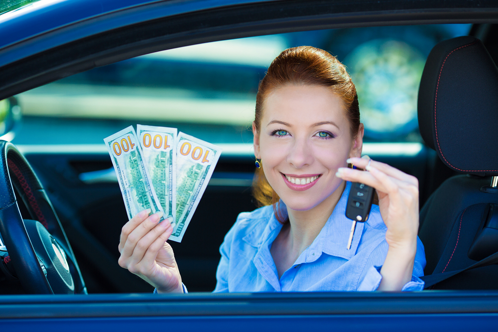 Customer holding car keys and cash after completing a vehicle trade-in transaction.