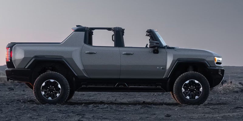 Gray GMC Hummer EV pickup truck on rugged terrain.